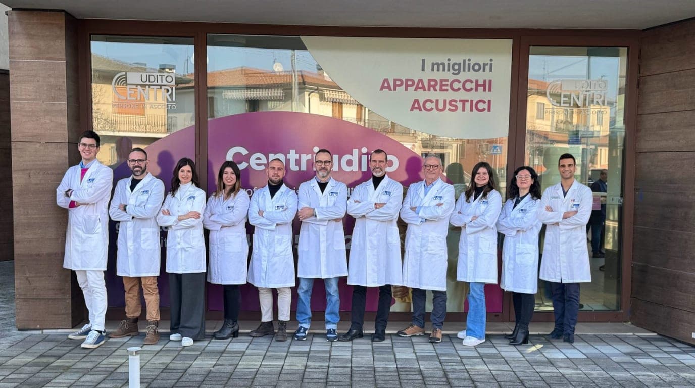 Il team Centriudito al completo, in camice davanti alla vetrina di un centro